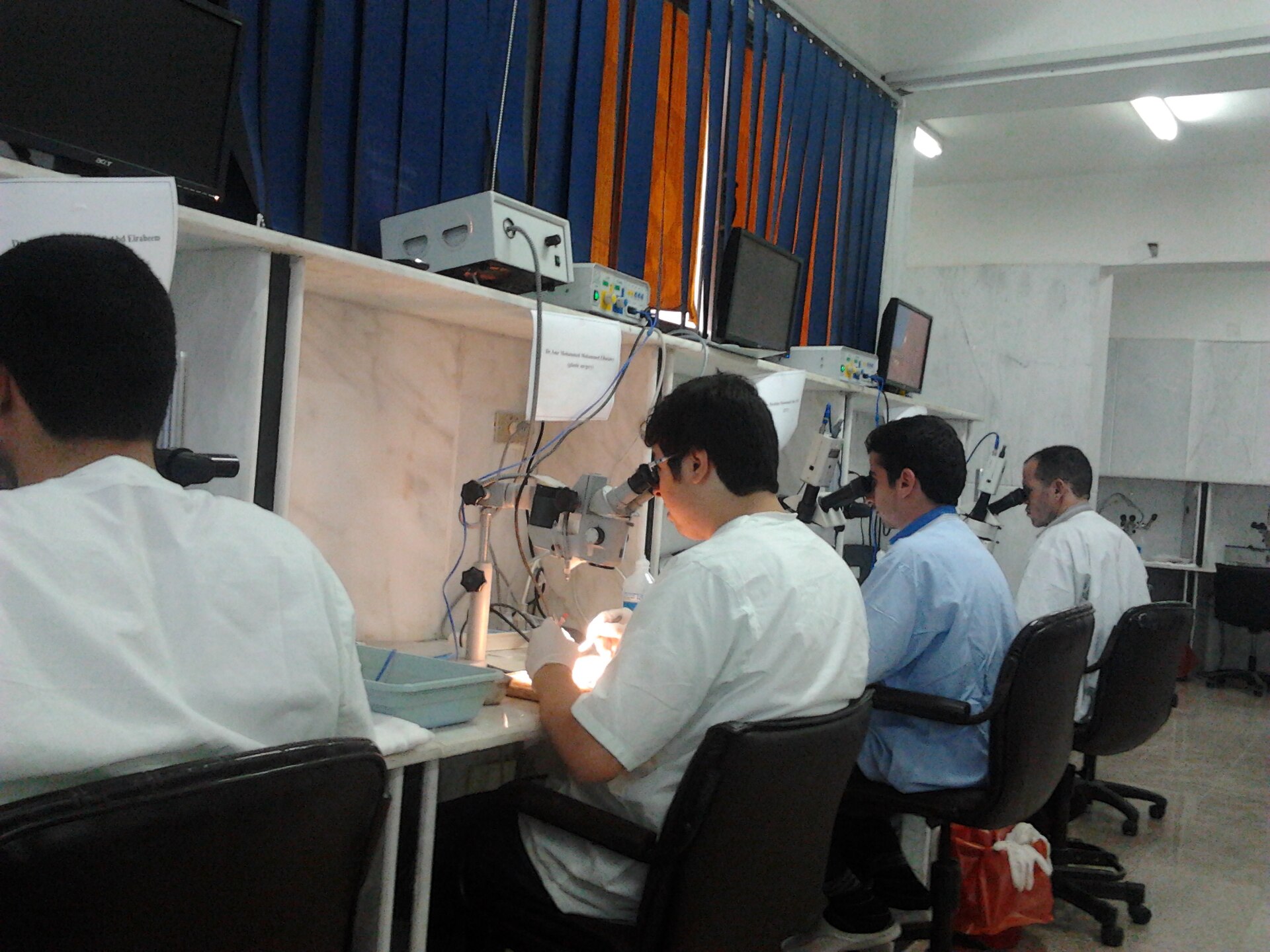 Laboratório de treinamento em microcirurgia, com cirurgiões em microscópios
